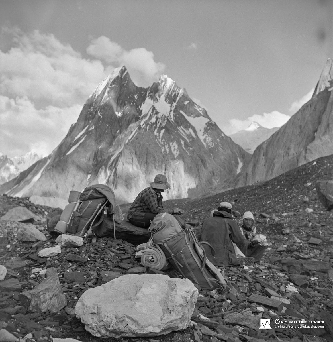 Biwak podczas powrotu z wyprawy. Od prawej: Andrzej Łapiński, Władysław Leszek Woźniak i NN. W tle Mitre Peak (6035 m n.p.m.).