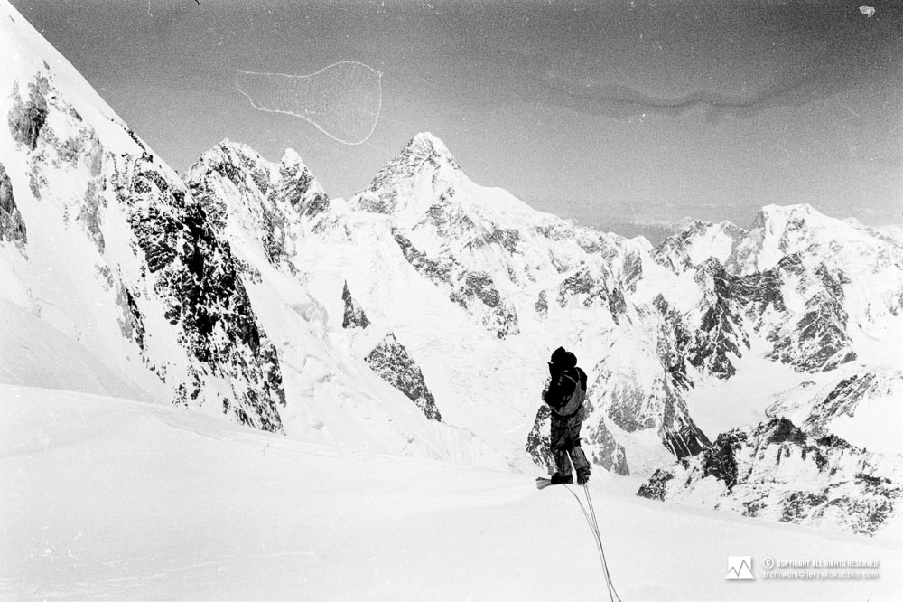 Wojciech Kurtyka on the slope of Gasherbrum II. Eight-thousanders are in the background. From the left: Broad Peak (8051 m above sea level) and K2 (8611 m above sea level).