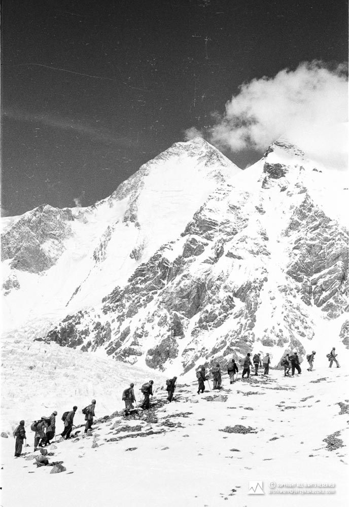 Porters leaving the base. In the background Gasherbrum I (8080 m above sea level).