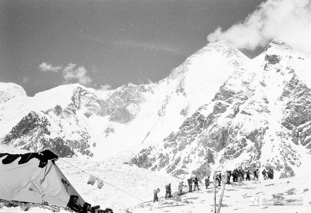 Porters leaving the base. In the background Gasherbrum I (8080 m above sea level).
