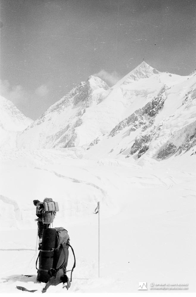 Wojciech Kurtyka na stoku Gasherbrum. W tle widoczne szczyty. Od lewej: Gasherbrum III (7952 m n.p.m.) oraz Gasherbrum II (8035 m n.p.m.).