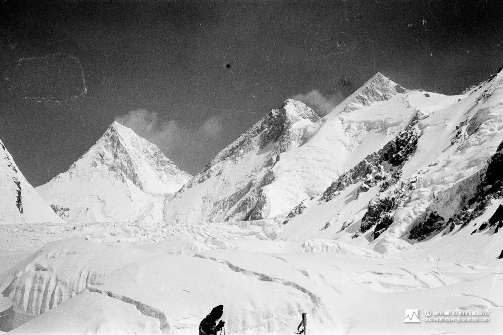 Wojciech Kurtyka na stoku Gasherbrum. W tle widoczne szczyty. Od lewej: Gasherbrum IV (7925 m n.p.m.), Gasherbrum III (7952 m n.p.m.) oraz Gasherbrum II (8035 m n.p.m.).