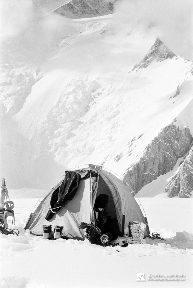 Wojciech Kurtyka w trakcie biwaku na stoku Gasherbrum. W tle widoczny Gasherbrum II (8035 m n.p.m.).