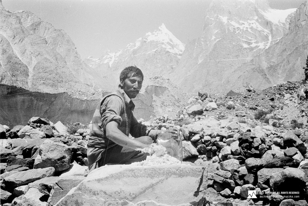 Porter during the caravan. In the background, the summit of Liligo Peak IV (6230 m above sea level) is visible.