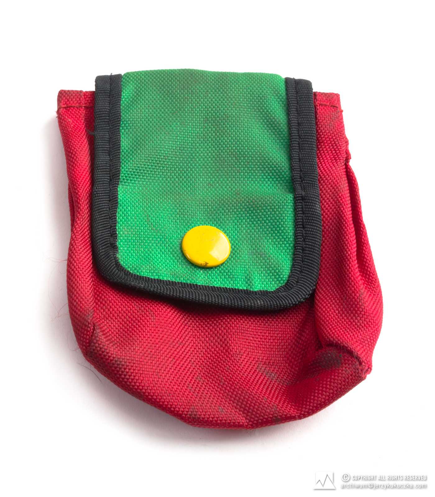 saszetka koloru czerwonego, klapa zielona, guzik żółty, zapinana na guzik, do przewlekania przez pas, długość- 10 cm, szerokość- 8.5 cm. Lata 60-80 XX w.
