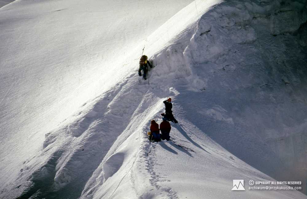 Himalaiści na stoku Manaslu. Jako pierwszy wspina się Wojtek Kurtyka, Artur Hajzer fotografuje wspinaczkę, za nim Carlos Carsolio (niebieski kask) i Elsa Avila czerwony kask).