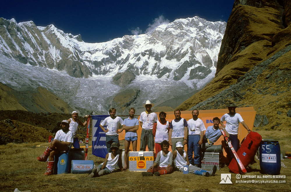 Participants of the expedition at the base. Ryszard Warecki is sitting on the barrel. From the left: Lech Korniszewski, Artur Hajzer, Phil Butler, Steve Untch, Francisco Espinoza, Jerzy Kukuczka, Janusz Majer, Alberto Soncini and Henry Todd. Base staff workers are sitting.