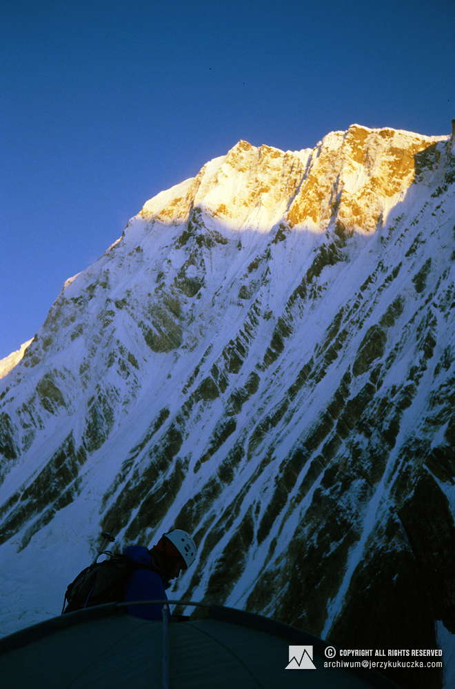 Artur Hajzer in camp II (6550 m above sea level). Annapurna I East peak (8010 m above sea level) is visible behind him.