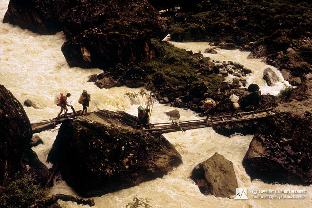 Uczestnicy wyprawy w trakcie przeprawy przez rzekę. Pierwszy od lewej Wojciech Kurtyka.