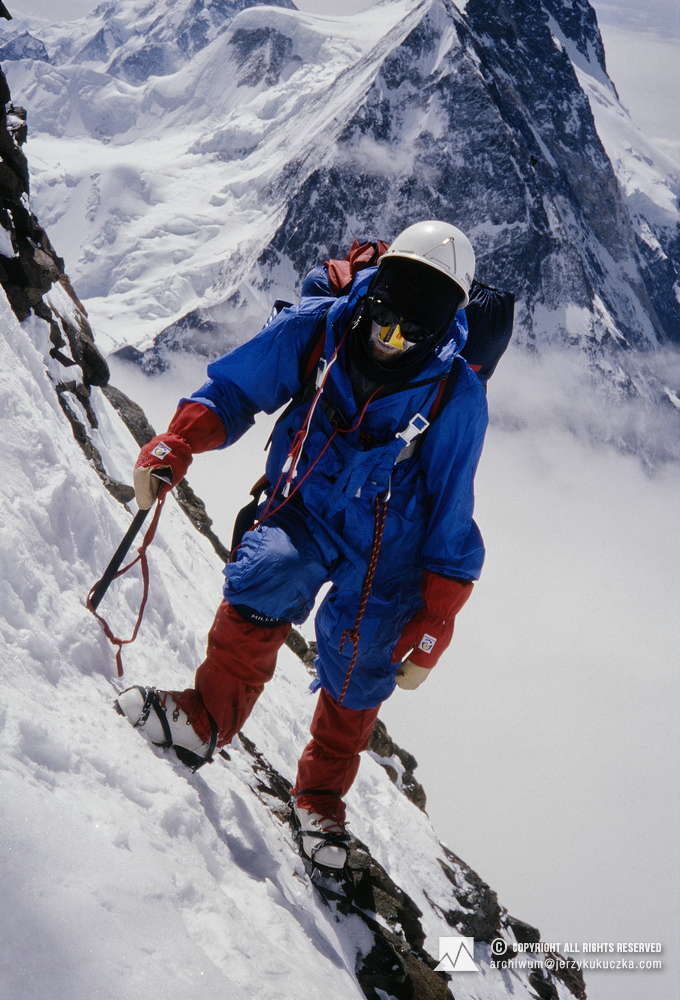Wojciech Kurtyka w ścianie K2. W tle masyw Broad Peak.