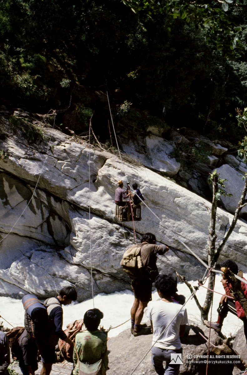 Tragarze podczas przeprawy przez rzekę za pomocą kolejki linowej.