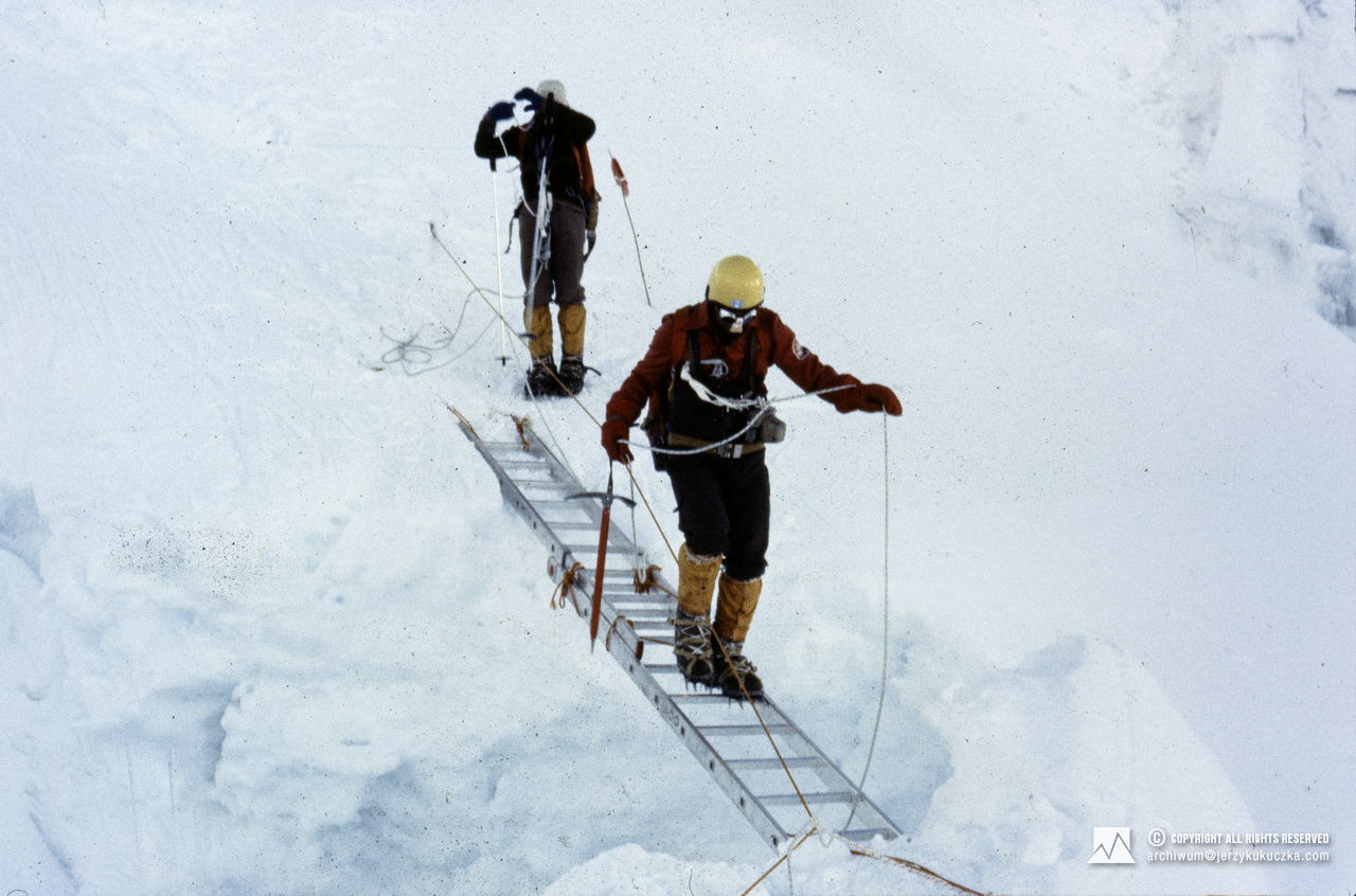 Uczestnicy wyprawy na lodospadzie Khumbu. Jerzy Kukuczka pokonuje lodową szczelinę, za nim Andrzej Czok.